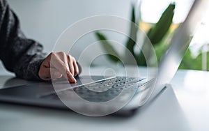 A woman working and touching on laptop computer touchpad on the table