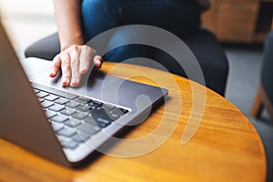 A woman working and touching on laptop computer touchpad on the table