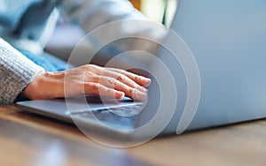 A woman working and touching on laptop computer touchpad on the table