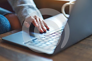 A woman working and touching on laptop computer touchpad on the table