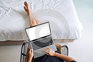 A woman working and touching on laptop touchpad with blank screen while sitting in bedroom at home