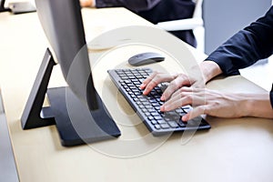 Woman working and typing on laptop computer keyboard in office