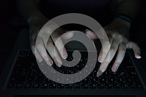 woman is working typing use laptop at dark night. Hands in the keyword with computer above typing. Late internet addiction or