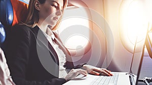 Woman working using laptop while travelling by plane