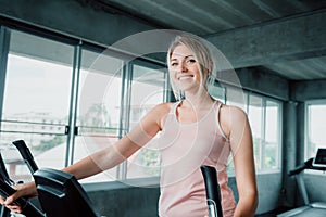 Woman workout elliptical trainer exercise in fitness gym., Portrait of pretty attractive caucasian woman doing elliptical trainer