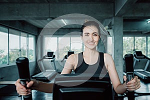 Woman workout elliptical trainer exercise in fitness gym., Portrait of pretty attractive caucasian woman doing elliptical trainer