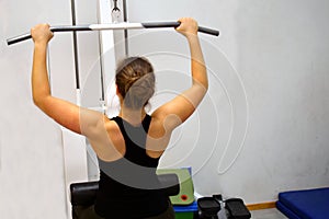 Woman workout with lat pulldown at the gym.