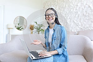 Woman works as an operator online. He sits with a laptop, headphones, conducts video consultations