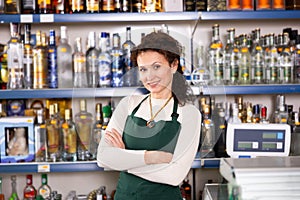 Woman works as salesperson in alcohol department of Russian store.