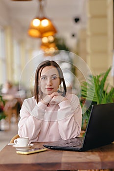 Woman works at a computer and ponders an idea