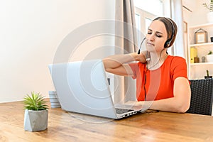 Woman works from home using headset and laptop