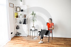 Woman works at home using headset and laptop