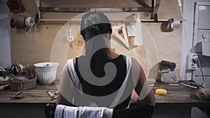 Woman works in pottery workshop