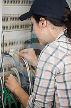 woman works in server room and switches wires