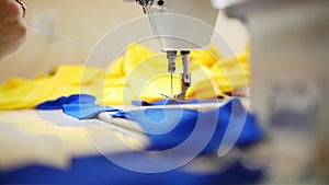 Woman works with textile on sewing machine. Focus on cloth