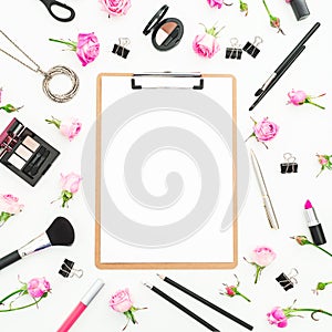 Woman workspace with cosmetics clipboard, accessories and pink roses on white background. Top view. Flat lay. Beauty blog backgrou