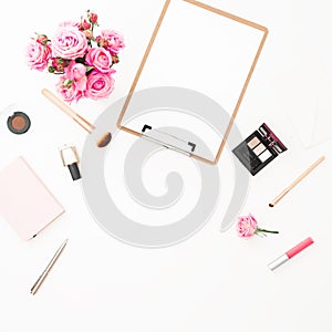 Woman workspace with pink roses bouquet, cosmetics, diary and clipboard on white background. Top view. Flat lay. Beauty blog, copy