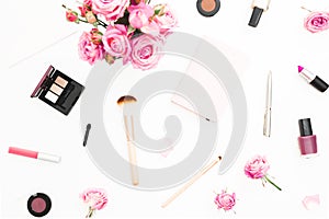 Woman workspace with pink roses bouquet, cosmetics, diary on white background. Top view. Flat lay home feminine desk. Beauty or fa