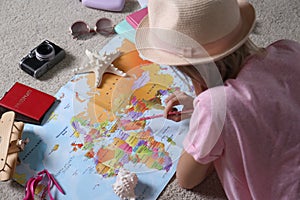 Woman with world map planning trip at home. Summer vacation