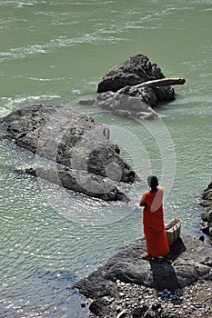 Woman worshipping by the Ganges river in Rishikesh, India