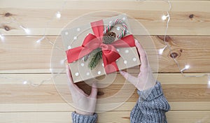 Woman wrapping Christmas gift at wooden table
