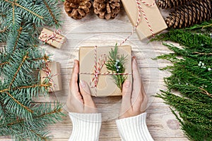 Woman wrapping modern Christmas gifts presents at home