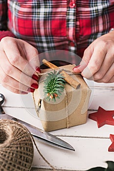 Woman wrapping natural christmas gift