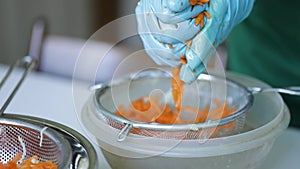 Woman wring out Grated carrots for cooking