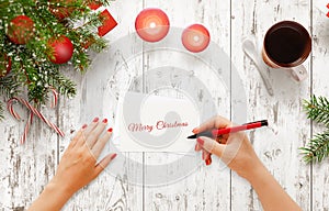 Woman write Christmas greeting message on paper