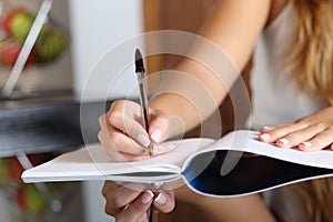 Woman writer hand writing in a notebook at home photo