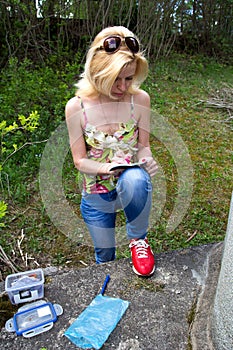 Woman writes in geocaching logbook photo