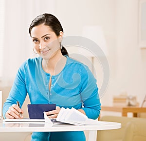 Woman writing check from checkbook photo