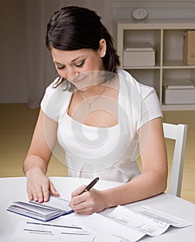 Woman writing checks from checkbook