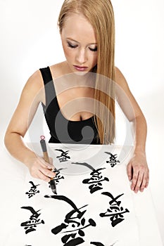 Woman writing Chinese Calligraphy: LOVE