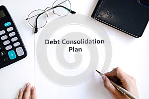 Woman writing debt consolidation plan in paper on desk. Copy space, top view