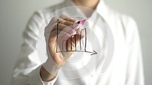 Woman writing growth graph on transparent screen. Businesswoman write on board