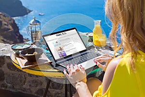 Woman writing her travel blog on laptop