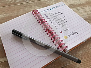 Bullet journal with a pen on a wooden desk