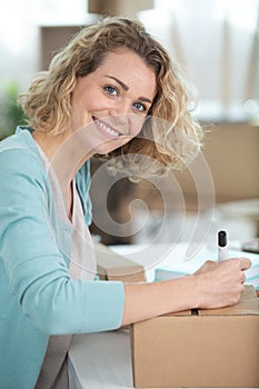 woman writing label on parcel