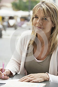 Woman Writing Letter At Outdoors Cafe