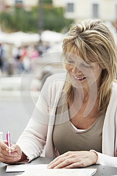 Woman Writing Letter At Outdoors Cafe