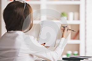 Woman writing in notepad