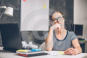 Woman writing notes and contemplating at the office photo