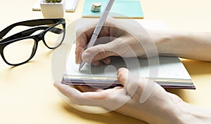 notes on desk, close up of hand