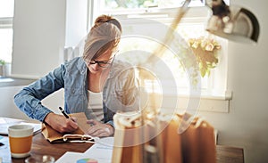 Woman Writing Notes on Paper Gift Bag on the Table