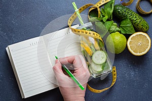 Woman writing nutrition plan diet menu and fitness workout routine