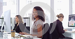 Woman, writing and office with computer, typing and happy for job, employee and consultant. Smile, young and confident