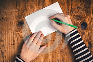 Woman writing recipient address on mailing envelope