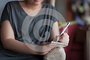 Woman writing on small notepad