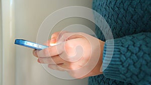 Woman writing sms on blue phone as a communication